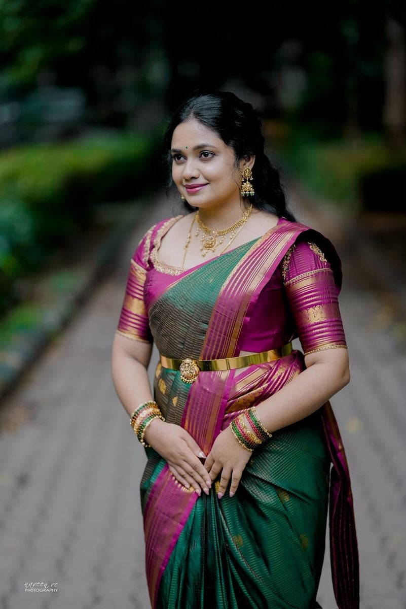 Model in an emerald and rani pink bridal silk saree